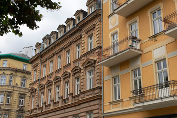 A large, impressive building featuring numerous windows and several balconies that enhance its architectural appeal significantly