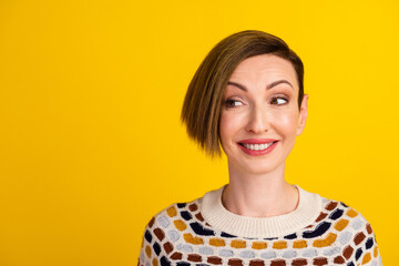 Pretty smiling female with fair hair dressed casually looking at camera isolated against blank studio yellow wall