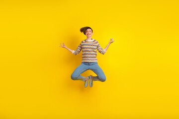 Full length photo of young girl jumping medicating concentrated dressed stylish outfit isolated yellow color background