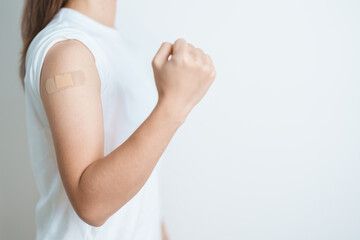 Woman with bandage after receiving vaccine. Vaccination and Immunization for Influenza, HPV,...