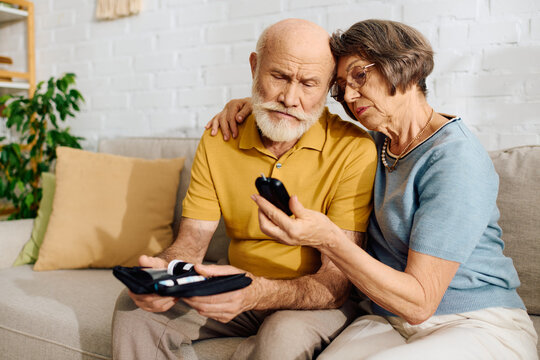 A devoted wife helps her husband monitor his diabetes while they sit together comfortably.