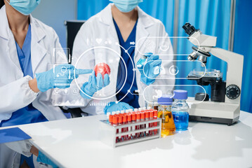 Fototapeta premium Scientists Analyzing Virus Models in Research Lab Using Digital Tablet and Microscopes