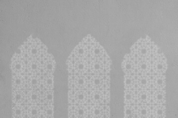 White shadow of three arched mosque windows on the wall