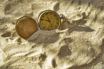 old pocket watch in the sand