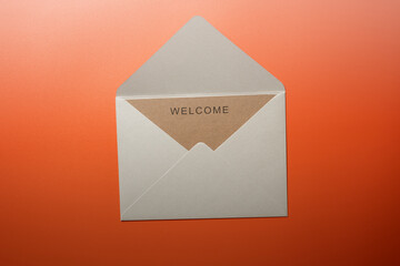 Top view of white envelope and postcard with brown card with words 