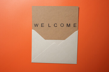 Top view of white envelope and postcard with brown card with words 