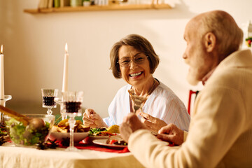 A joyful senior couple enjoys a festive Christmas dinner at home.