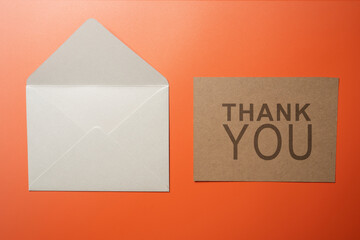 Top view of white envelope and postcard with brown card with words 