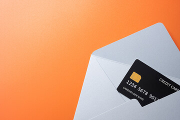 Top view of empty blank white envelope and postcard with credit card on colored background