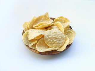 Opak singkong or cassava chips in wooden plate isolated on white background. Indonesian traditional foods