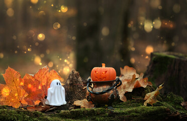 witch cauldron with decorative halloween pumpkin and ghost in autumnal forest, abstract nature...