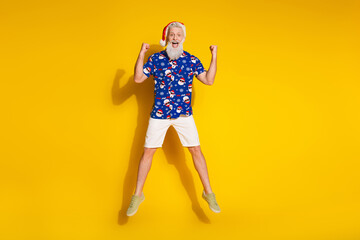 Full size photo of stylish modern santa raise fists jump wear x-mas winter print shirt isolated on yellow color background