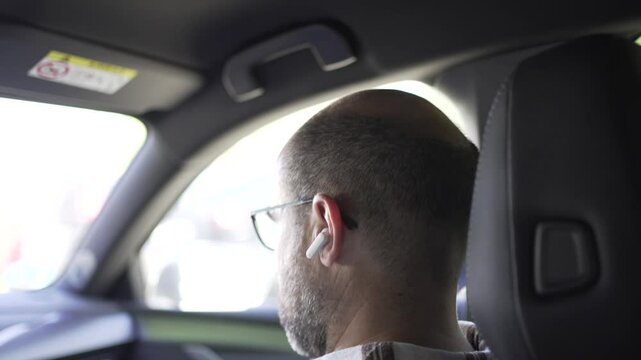 male co-driver with wireless headphones listening to music, action in which he removes the headphones.