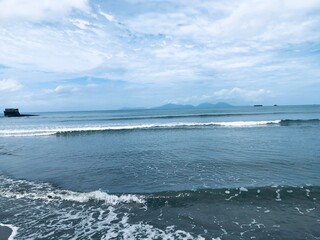 The calm sea waves on the beach are very beautiful and cool.
