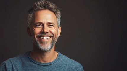Fototapeta premium A man with gray hair and a beard smiles at the camera.