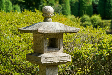 Die Steinlaterne steht elegant in einem üppig grünen Garten