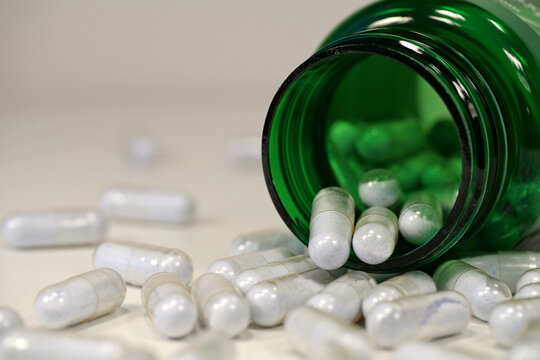 Capsules with blue powder scattered on table, tablets of copper in chelated form