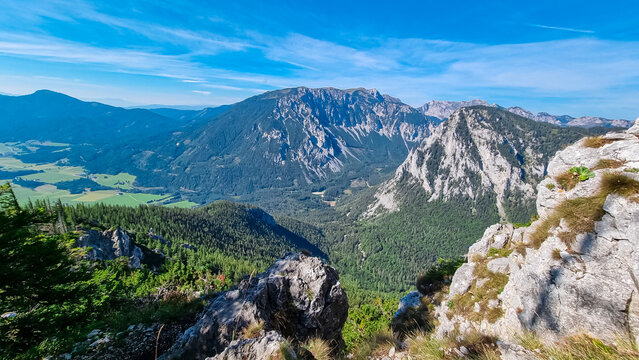 Majestic mountain range Hochschwab seen from near mountain peak Messnerin, Styria, Austria. Slopes covered in lush green forests. Rugged rocky terrain with towering peaks. Hiking in Austrian Alps