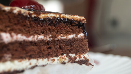 The cherry on top of the cake. Chocolate cake with a cherry on top.