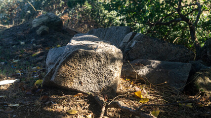 Part of the big stone is in the shade, and the other part is in the sunlight