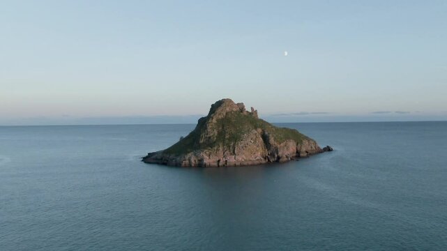 Thatcher Rock Torquay Drone Footage In the English riviera, sunny day, beautiful sky Ariel view of scenic landscape With moon in background 