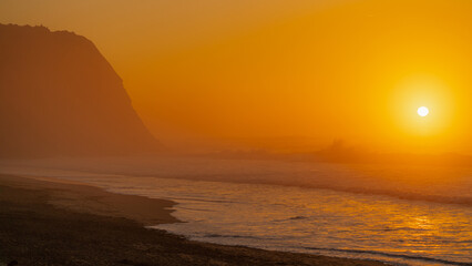 Serene Sunset Over Ocean Waves and Sandy Beach
