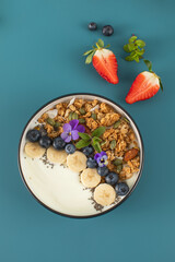 A healthy nutritious breakfast of natural Greek yoghurts, granola and fresh berries.