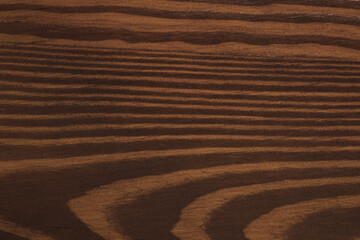 Texture of wooden surface after applying walnut wood stain as background, closeup