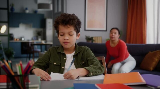 Little African American child boy kid studying at home pretend study mother controlling woman female mom girl walk away son take mobile phone playing online game play smartphone addiction gen z addict