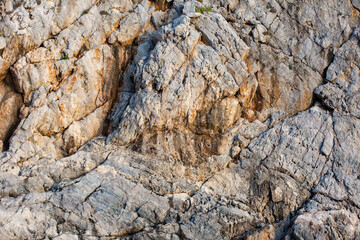 Brown colored Basalt sheer rocks  cuted by cracks due geology and by constant wind and temperature fluctuations. This cliff downs to  blue water of  the see