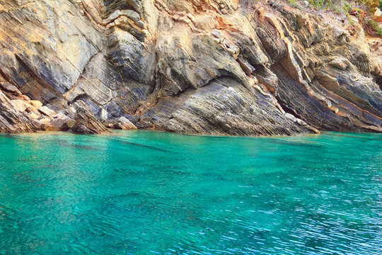 Beautiful scenic view - colorful bright blue water of Aegean Sea, rugged coast beach in Kelifos island between Kassandra and Sithonia of Chalkidiki (Halkidiki) peninsula, Greece, South Europe