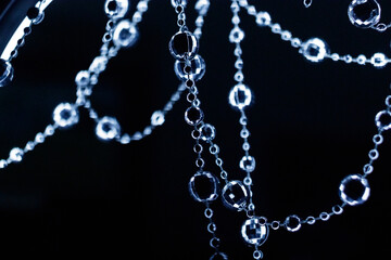 Crystal disco beads hanging garland shining on dark background. Christmas, New Year 2025
