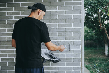 Man Priming Wall with Paint Roller