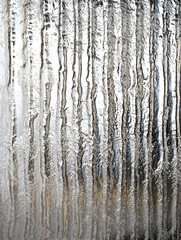 Obraz premium Frosted polycarbonate surface with metallic chrome reflections. Vertical ribbed patterns with abstract textured effect. Cool toned icy palette. 