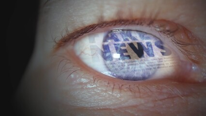 Fototapeta premium Macro of a human female eye in which headlines about fake news and media manipulation are reflected, concept of fake news on the internet and social media