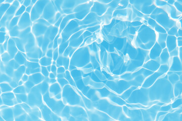 Blue water with ripples on the surface. Defocus blurred transparent blue colored clear calm water surface texture with splashes and bubbles. Water waves with shining pattern texture background.