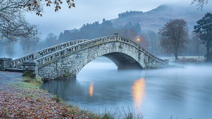 Fototapeta premium Enchanting Medieval Stone Bridge Over Misty River at Dawn