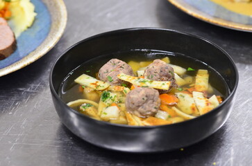 Traditional Beef Broth with Dumplings, Vegetables, and Noodles Served in a Restaurant