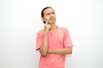 Asian, Indonesian man standing with his hand on his chin and head as if in deep thought, thinking...