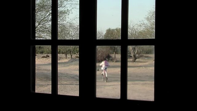 Blurred Girl on a Bicycle Heading to School, Seen from a Farm Window, Santiago del Estero, Argentina