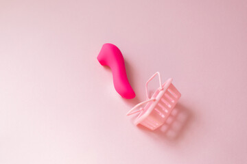 pink vibrating sex toy with cart a pink background