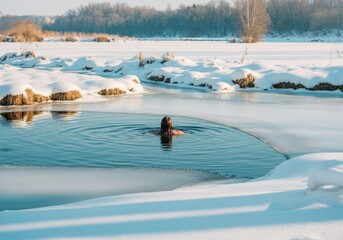 Young man is enjoying the benefits of cold water therapy by swimming in a frozen lake on a sunny winter day