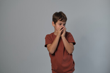 Boy in casual attire impersonates a wild creature, eyes popped and roaring. Reminds viewers of the uninhibited spirit of childhood and the universality of Youngster dramatizes a scare.