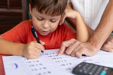 A six-year-old boy with dysgraphia and dyscalculia works on his math homework.