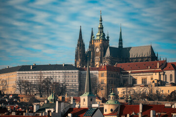 Naklejka premium Exploring the historic skyline of Prague, featuring the majestic Prague Castle under a clear blue sky