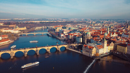 Fototapeta premium Aerial view of Prague showcasing historic bridges, colorful rooftops, and the Vltava River during a clear day