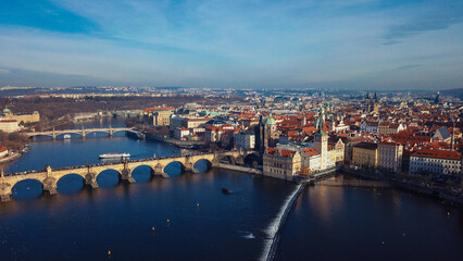 Stunning aerial view of Prague showcasing the iconic Charles Bridge and the Vltava River under a clear blue sky