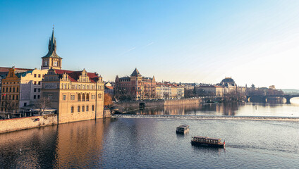 Sunrise over the Vltava River highlighting historic buildings and boat activity in Prague
