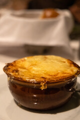 A bowl of French onion soup topped with melted cheese