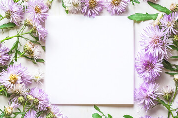 Asters springtime scenery, nature background. Festive holiday greeting card for Birthday, Woman or Mothers Day, blank copy paper and a greeting card. View from above.